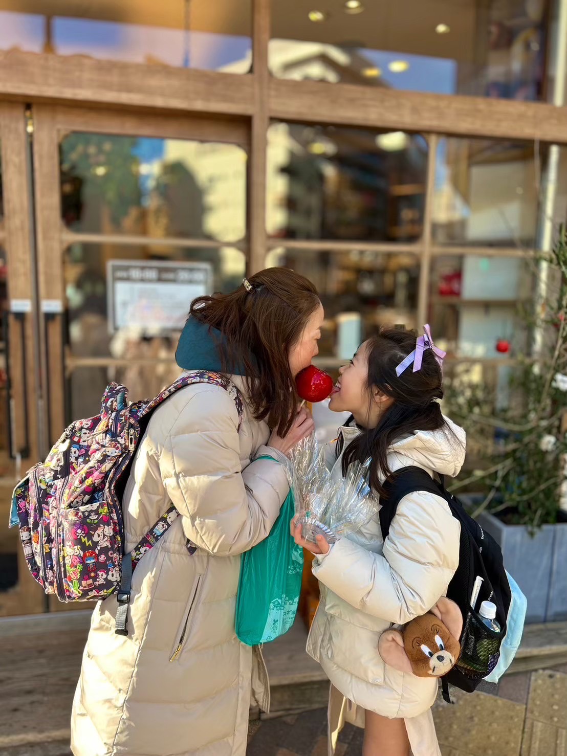 娘と一つのりんご飴を食べてる写真